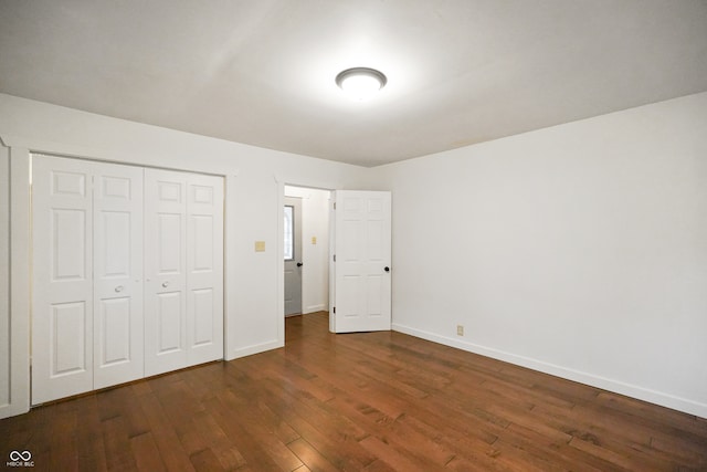 unfurnished bedroom featuring a closet and dark hardwood / wood-style floors