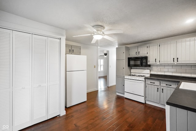 kitchen with gray cabinetry, backsplash, white appliances, ceiling fan, and dark hardwood / wood-style floors