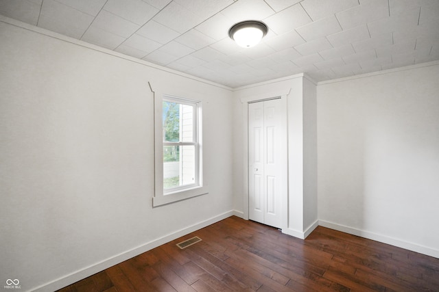 empty room featuring crown molding and dark hardwood / wood-style flooring