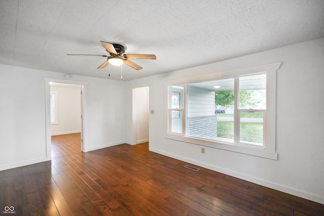 unfurnished room featuring ceiling fan and dark wood-type flooring