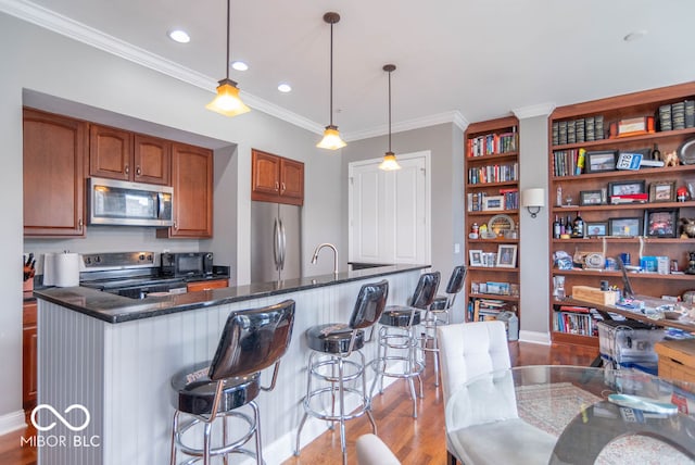 kitchen with appliances with stainless steel finishes, hanging light fixtures, dark stone counters, ornamental molding, and sink