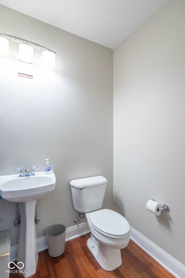 bathroom featuring wood-type flooring and toilet