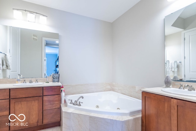 bathroom featuring vanity and a relaxing tiled tub