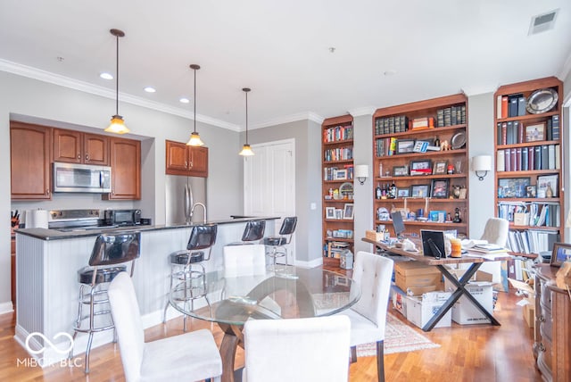 dining space featuring light hardwood / wood-style flooring and crown molding