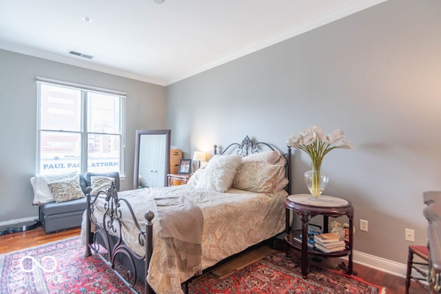 bedroom with hardwood / wood-style flooring and ornamental molding