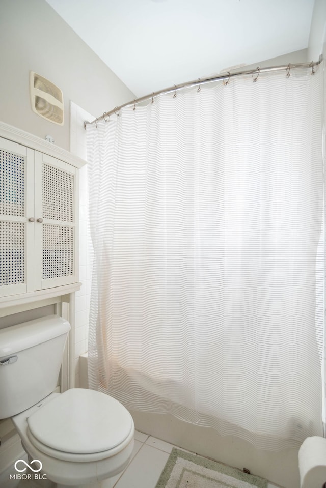 bathroom with shower / bathtub combination with curtain, tile patterned flooring, and toilet