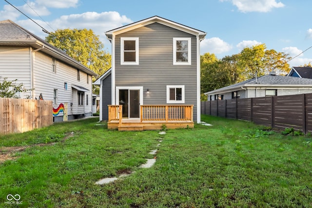 rear view of property with a deck and a lawn