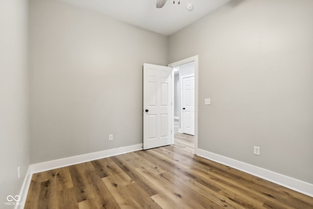 empty room with hardwood / wood-style floors and ceiling fan