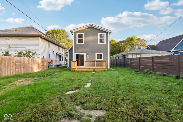 rear view of property with a wooden deck and a yard