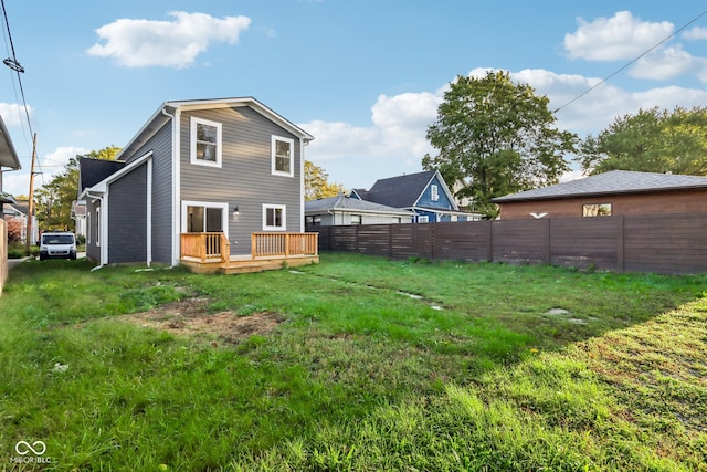 back of house with a deck and a yard