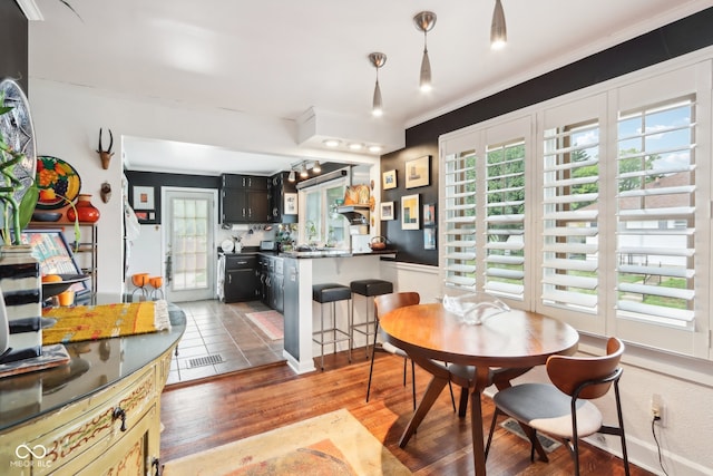 dining space with ornamental molding and hardwood / wood-style floors