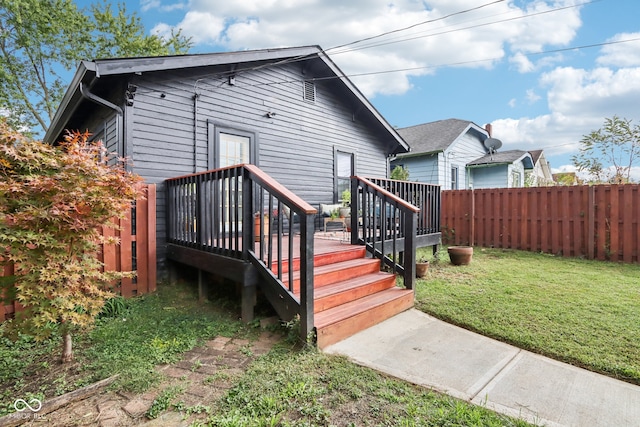 back of house with a lawn and a wooden deck