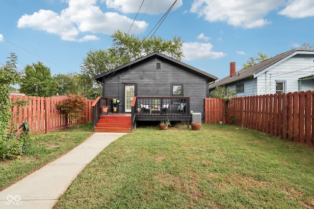 back of property with a yard, a deck, and central air condition unit