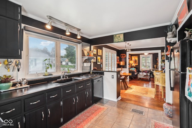 kitchen featuring light hardwood / wood-style flooring, black appliances, ornamental molding, and sink