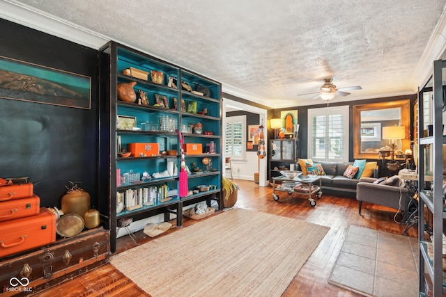 sitting room with wood-type flooring, a textured ceiling, crown molding, and ceiling fan