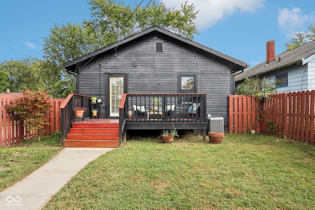 rear view of house with central AC, a deck, and a yard