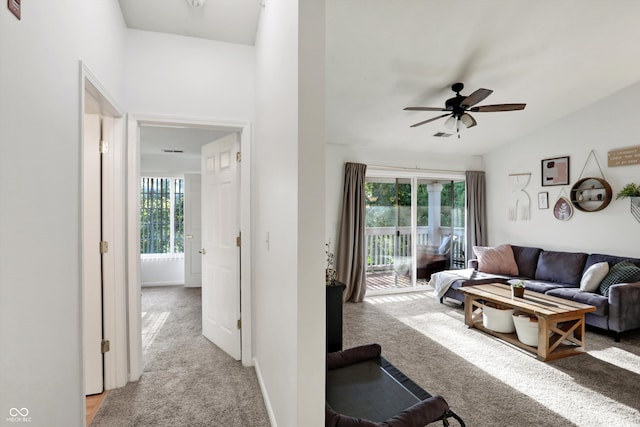 carpeted living room with lofted ceiling, ceiling fan, and a healthy amount of sunlight