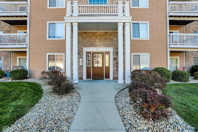 view of exterior entry with a balcony