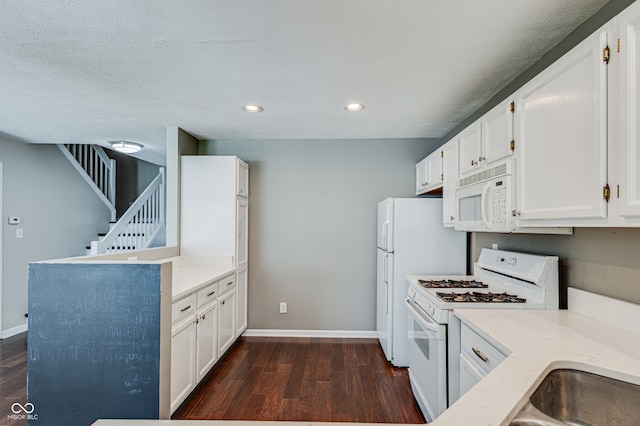 kitchen featuring white cabinets, a textured ceiling, white appliances, and dark wood-type flooring