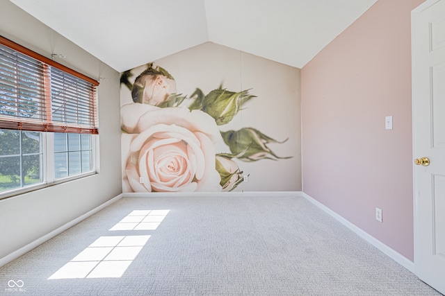 carpeted empty room featuring lofted ceiling