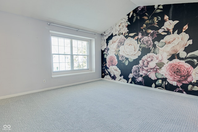 empty room with carpet floors and vaulted ceiling