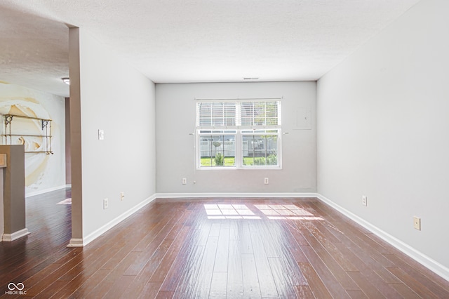 empty room featuring a textured ceiling and dark wood-type flooring