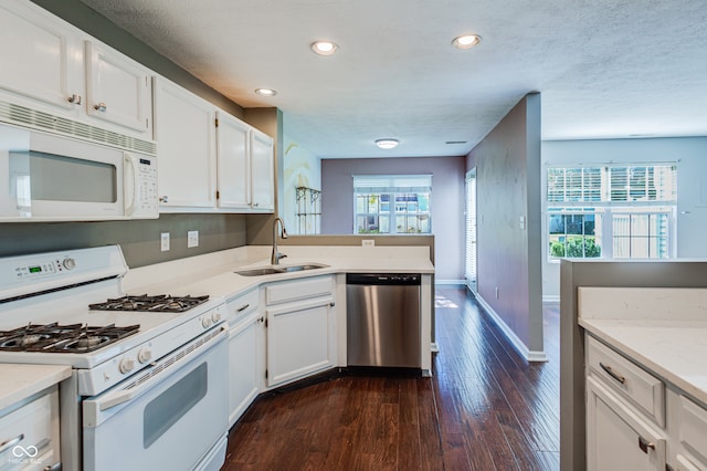 kitchen featuring plenty of natural light, white cabinetry, white appliances, and sink