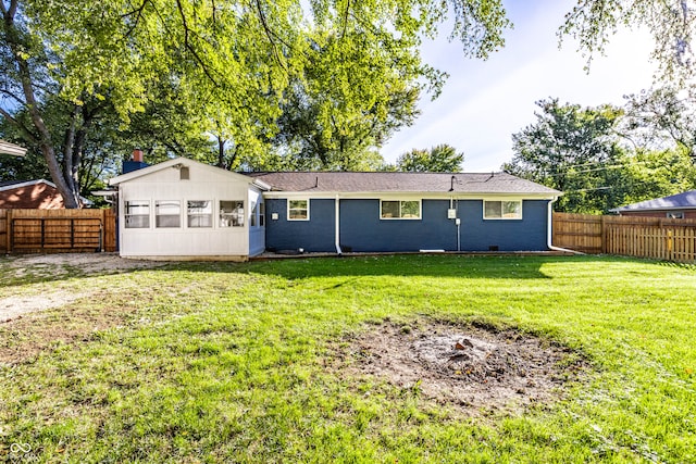 rear view of house featuring a lawn