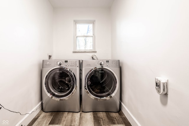 washroom with washing machine and dryer and hardwood / wood-style flooring