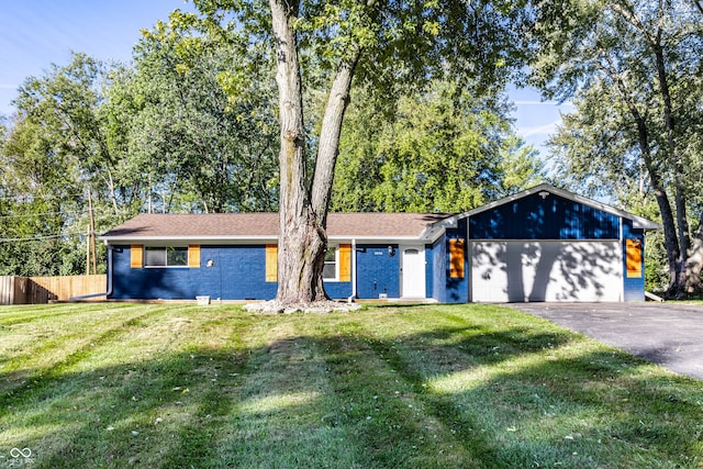 ranch-style home featuring a front lawn and a garage