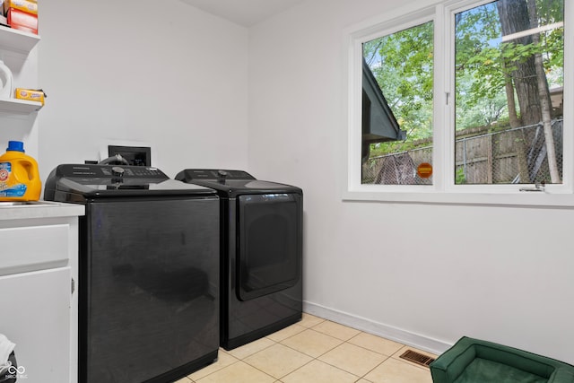 laundry room with separate washer and dryer and light tile patterned floors