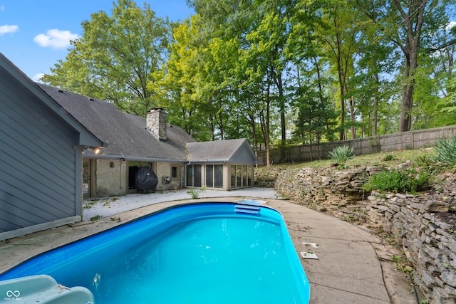 view of pool featuring a sunroom and a patio