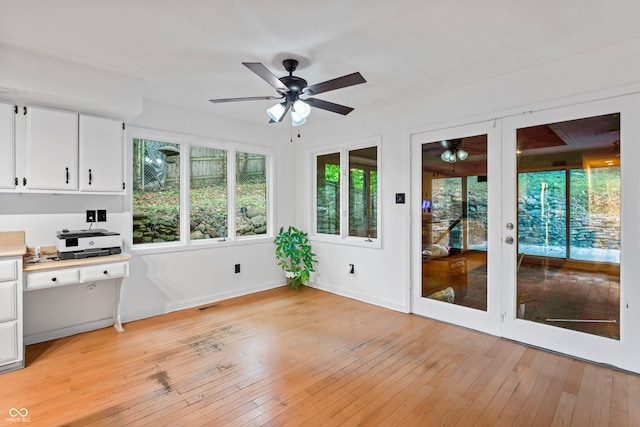 unfurnished sunroom with ceiling fan and french doors