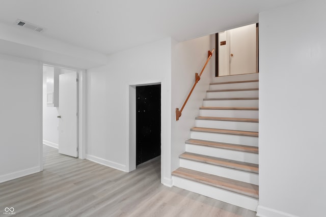 stairs featuring hardwood / wood-style floors