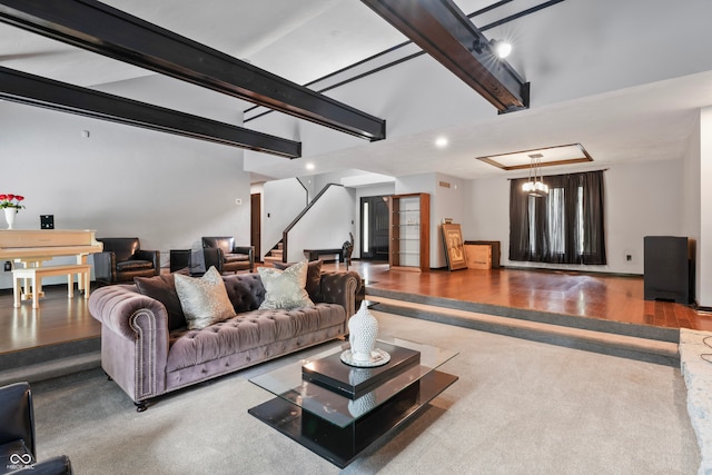 living room with a notable chandelier, beamed ceiling, and hardwood / wood-style flooring