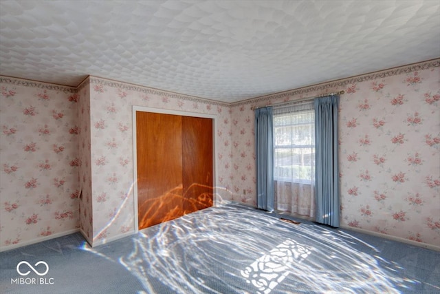 unfurnished bedroom featuring a textured ceiling and carpet