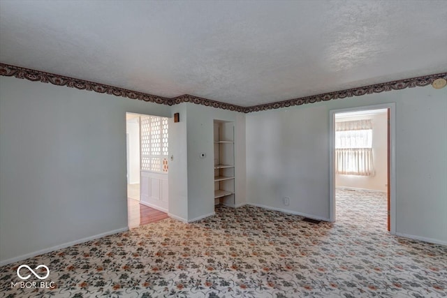 empty room featuring light carpet and a textured ceiling