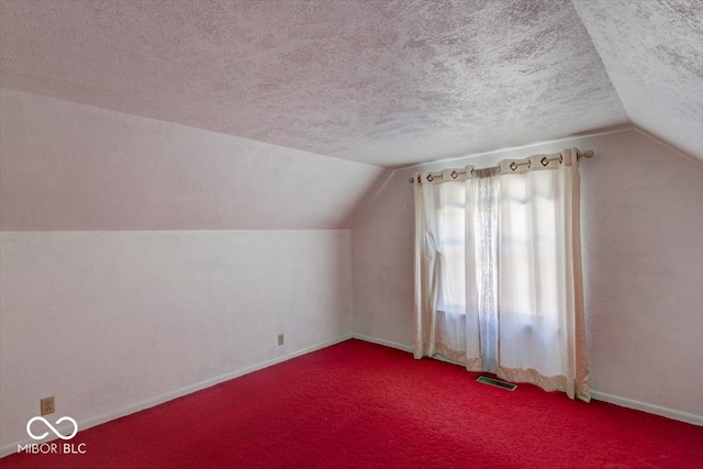 bonus room with carpet floors, a textured ceiling, and vaulted ceiling