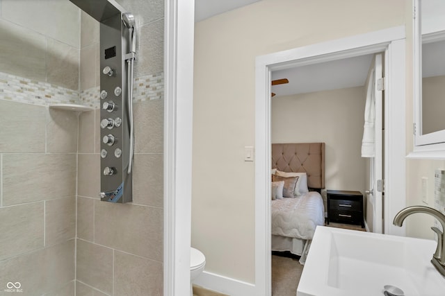 bathroom featuring toilet, sink, and tiled shower