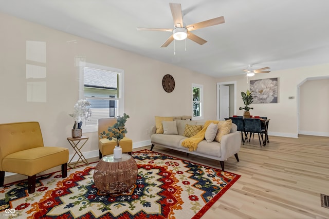 living room featuring ceiling fan, light hardwood / wood-style flooring, and plenty of natural light