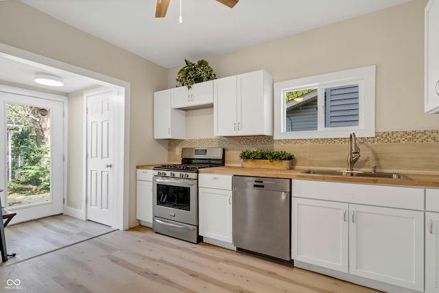 kitchen with white cabinets, appliances with stainless steel finishes, sink, and a wealth of natural light