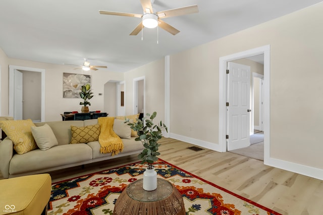 living room with ceiling fan and light hardwood / wood-style flooring