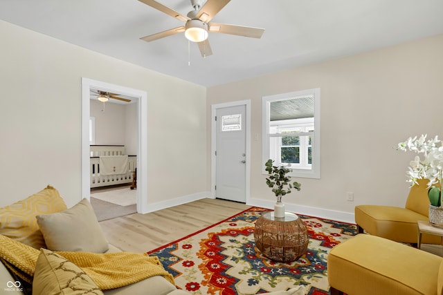 living room featuring light hardwood / wood-style flooring and ceiling fan