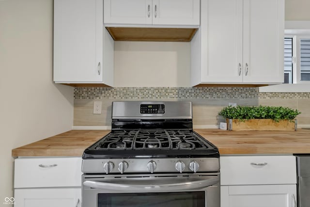 kitchen featuring white cabinets, stainless steel gas stove, wood counters, and decorative backsplash