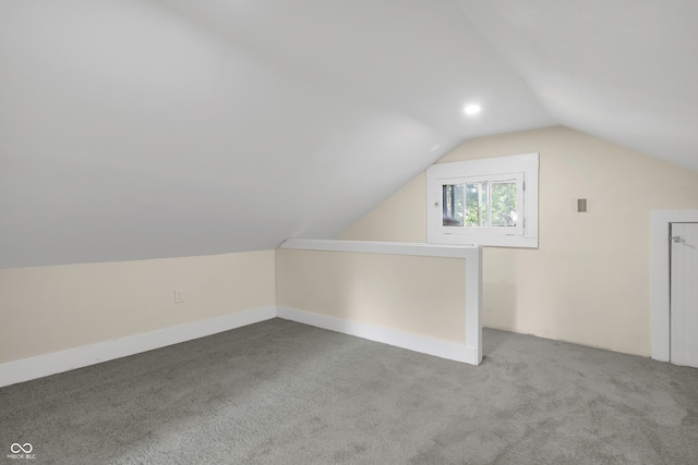 additional living space featuring lofted ceiling and carpet