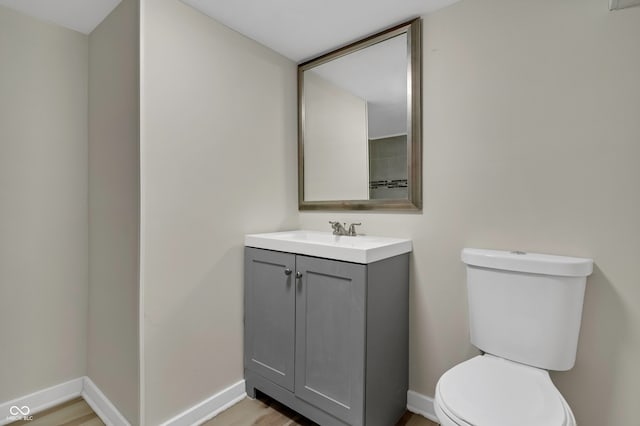 bathroom with wood-type flooring, vanity, and toilet