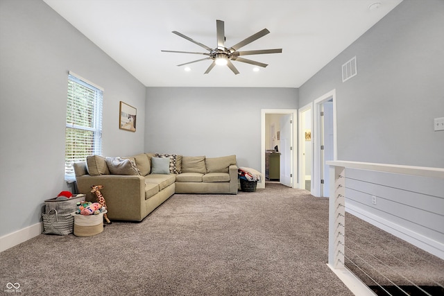 carpeted living room featuring baseboards, visible vents, and a ceiling fan