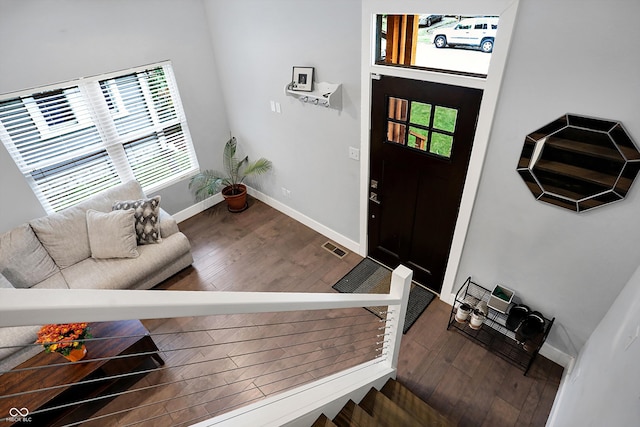 foyer entrance with visible vents, baseboards, and wood finished floors