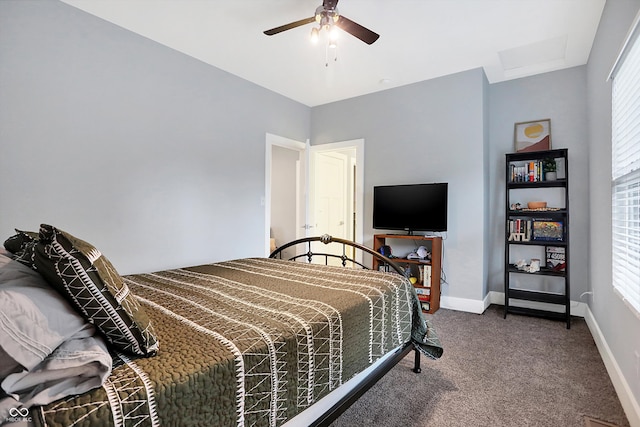 carpeted bedroom featuring a ceiling fan, attic access, and baseboards