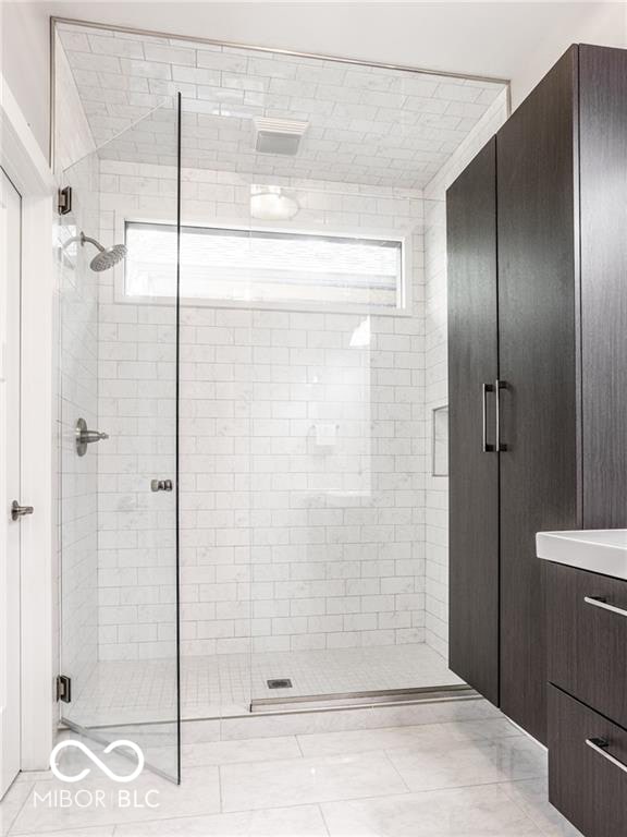 full bathroom with a shower stall and vanity